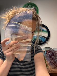 the artist stevie davies, hold up a piece of fused glass